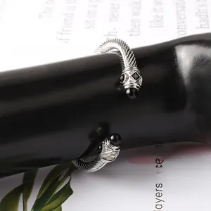 Dettaglio del bracciale a cavo ritorto argento con pietre nere su mano da esposizione
