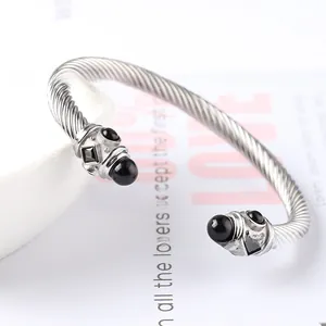 Vista macro del bracciale a cavo d'argento con pietre nere e texture a spirale