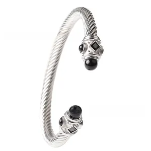 Dettaglio ravvicinato del bracciale a cavo intrecciato argento con estremità in gemma nera