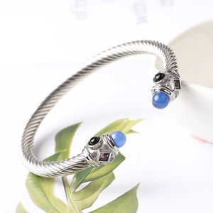 Dettaglio del bracciale a cavo intrecciato con gemme blu e accenti di cristallo viola