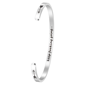 Detail of 4mm stainless steel cuff bangle with engraved motivational quote and arrow