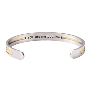 Detail view of steel cuff bracelet with golden inlay and YOU are unstoppable engraving
