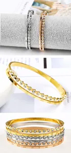 Detailed close-up of Roman numeral engraved bangles with crystal inlay in three colors