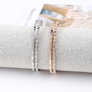 Close-up of double-layer roman numeral bracelets with sparkling crystals in silver and rose gold
