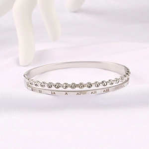 Macro detail of silver double-layered bangle with Roman numerals and sparkling zircons