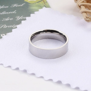 Detail view of a 6mm polished stainless steel ring on a cleaning cloth at 45-degree angle