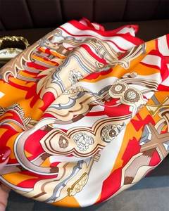 Detailed close-up of luxury silk scarf featuring vintage chain and buckle equestrian motifs