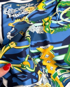Detailed view of luxury silk scarf with equestrian chain patterns and green twill texture