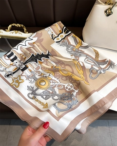 Macro detail of silk square scarf featuring nautical anchors and chain patterns on beige