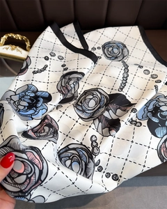 Detail of camellia silk scarf showing floral print and elegant pearl chain patterns