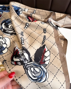 Close-up of silk-textured camellia scarf showing elegant floral pattern and draped fabric