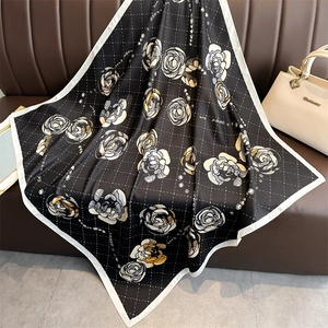 Detail of camellia silk scarf with black white grid pattern on leather backdrop