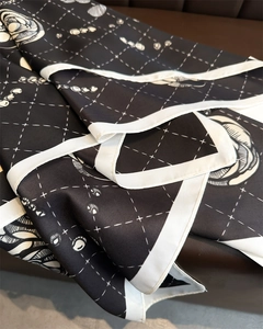 Close-up of silk scarf showing camellia rose pattern with elegant diamond lattice print