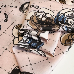 Detailed close-up of pink camellia twill silk scarf showing elegant floral and grid patterns