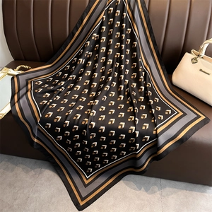 Detail of silk square scarf showing luxury geometric patterns and smooth satin texture