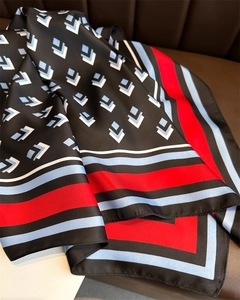 Detailed view of glossy twill silk scarf with geometric square pattern and vibrant colors