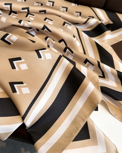 Detailed view of luxury square silk scarf showing high-end twill texture and geometric patterns