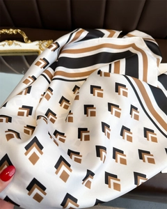 Macro view of geometric patterned silk scarf with premium twill texture and striped edges
