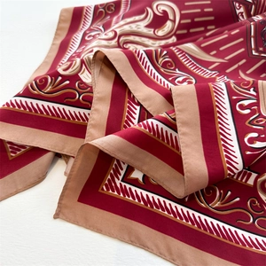Detailed close-up of red Baroque silk scarf showing satin texture and ornate patterns