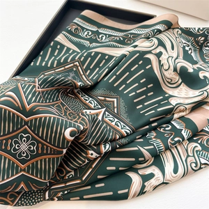 Detailed close-up of dark green geometric baroque silk scarf with exquisite satin finish