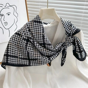 Dettaglio del foulard in seta con motivo pied de poule bianco e nero su abito