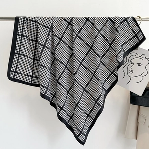 Dettaglio di sciarpa in seta pied-de-poule bianca e nera con drappeggio elegante e liscio