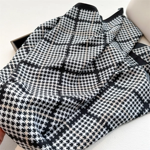 Dettaglio di elegante foulard in seta pied-de-poule bianco e nero con finitura satinata