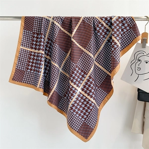 Dettaglio della trama del foulard in seta pied de poule marrone e blu con scritta