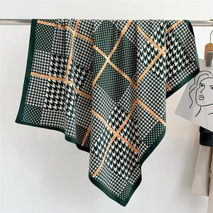 Dettaglio foulard in seta pied de poule verde con bordi arrotolati e stampa logo moda