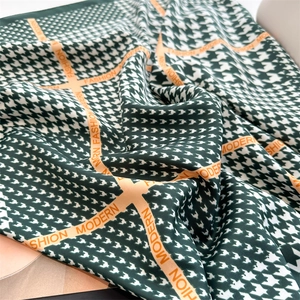 Dettaglio di sciarpa in seta pied de poule verde con nastro Fashion Modern e trama fine
