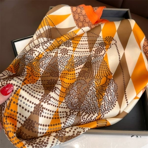 Detail of diamond pattern silk scarf with orange and brown geometric chain print texture