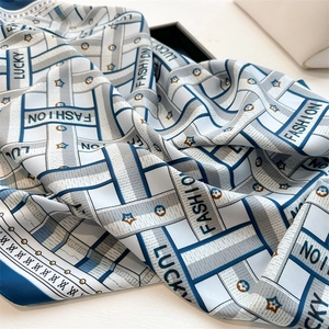 Detail of herringbone silk scarf with blue and grey stripes and Lucky Fashion lettering
