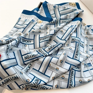 Detail of herringbone pattern silk scarf with Lucky Fashion lettering and floral icons