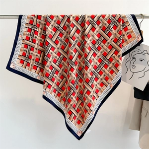 Detail of red and navy printed satin scarf showing Lucky and Fashion letter patterns