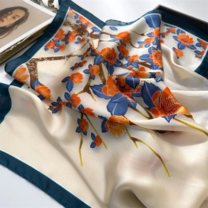 70cm floral silk scarf with vibrant blue and orange blooms on a cream base with green border