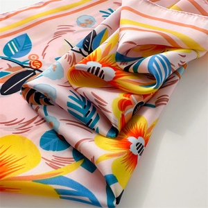 Macro shot of silk scarf showing bright floral patterns and smooth fabric texture