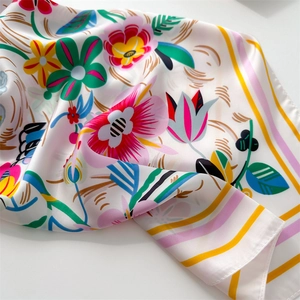 Close-up of floral geometric print silk-like scarf with vibrant satin finish details