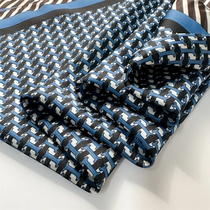 Détail macro de la texture du foulard en soie avec imprimé géométrique bleu et brun