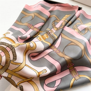 Macro detail of silk-like scarf featuring vintage chain belt patterns and smooth texture