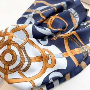 Detail of elegant equestrian print on silk scarf with metal chains and leather buckles