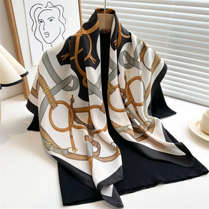 Retro chain print silk square scarf with equestrian motifs draped on a wooden hanger