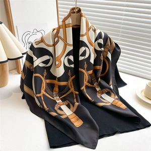 Close-up of vintage chain and equestrian print silk scarf draped on a black hanger