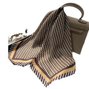 Élégant foulard en soie 70cm avec motif géométrique drapé sur un sac à main en cuir chic