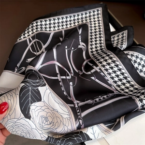 Détail de l'imprimé pied-de-poule et fleurs de camélia sur un foulard en soie satinée