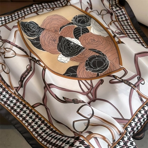 Détail d'un foulard en soie montrant l'imprimé camélia et le motif pied-de-poule chic