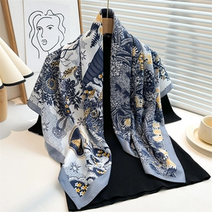 Detail view of sunflower pattern silk scarf draped over a classic black sweater
