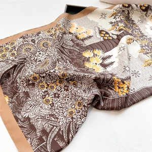 Macro view of sunflower silk scarf featuring retro floral patterns and star motifs