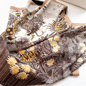Detail of silk satin scarf featuring vintage sunflower print and smooth glossy texture