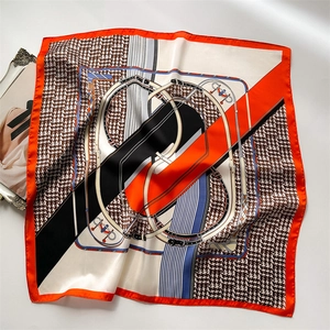 Orange silk square scarf with equestrian bridle print and houndstooth pattern detail