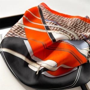 Detailed macro view of silk scarf with orange and black equestrian belt patterns